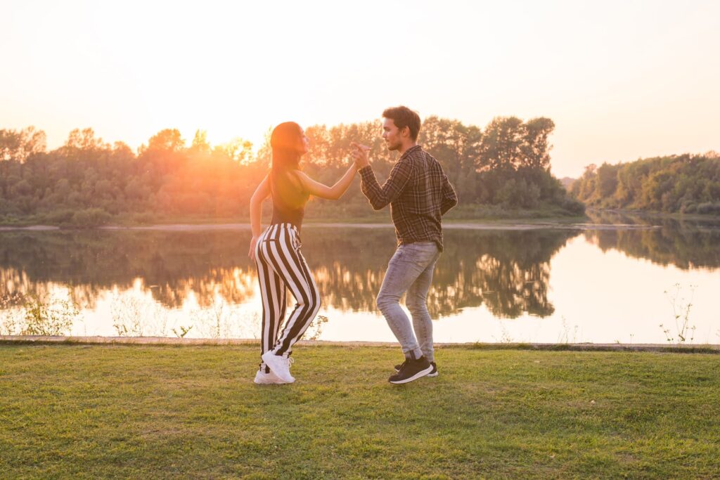 Una pareja bailando bachata en el campo - tipos de bachata